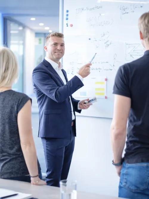Consultant explaining ideas to a team at a whiteboard