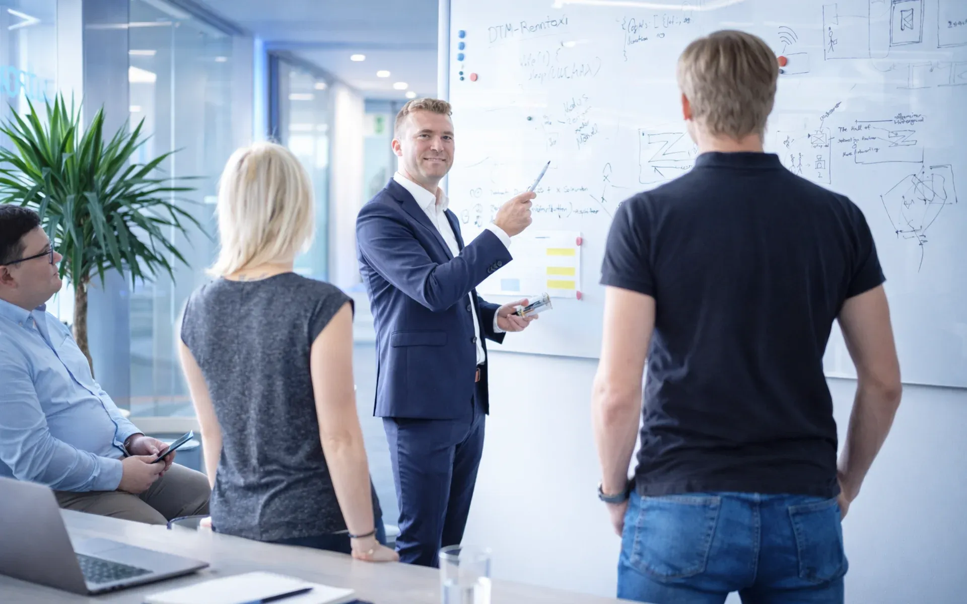 Consultant explaining ideas to a team at a whiteboard